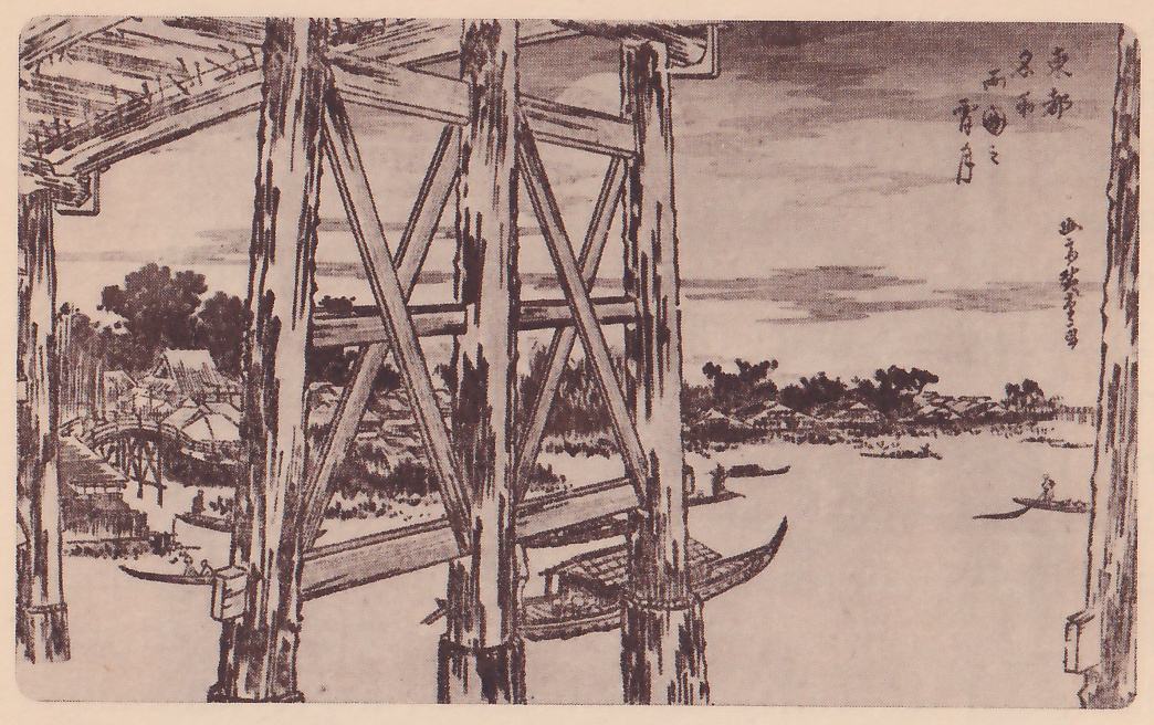 Print seen from under a wooden bridge: heavy braced timber posts and beams fill the foreground, and beyond them a wide river with boats on it, a bridge and low buildings along the left bank, and trees and low roofs along the far shore under a cloudy sky. A boat with a flat roofed cabin lies under the bridge at the center. Title writing and a signature are at the upper right.