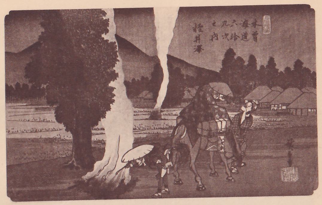 Print of a village road at dusk: a large dark tree stands at the left beside a pale trunk that rises past the top edge, and a thin column of white smoke rises from the ground at the center past the top edge. Thatched houses and flat fields lie beyond, with dark hills behind. At the center a loaded horse with a rider under a round hat stands beside a person in a checked robe, and at its left a person bends forward under a large round hat at the foot of the pale trunk. Title writing is at the upper right and a signature and seal at the lower right.