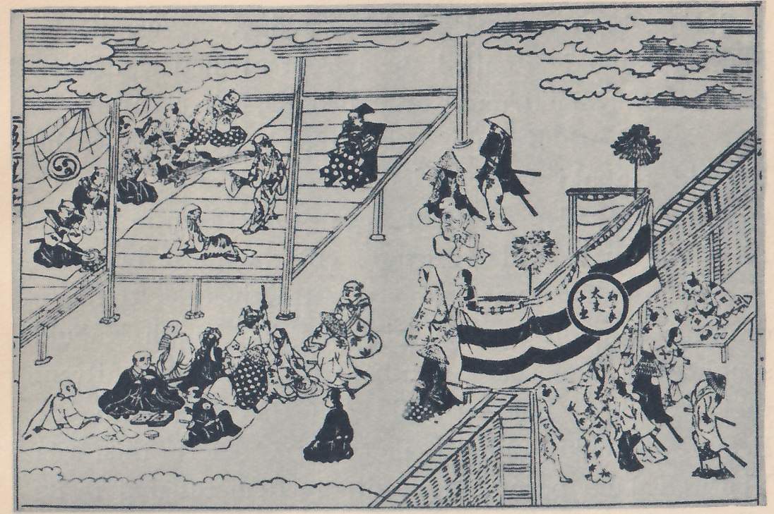 Line print of a busy scene around a raised wooden floor seen from above. At the upper left people sit and stand on the boards under a cloth hung with a round swirl crest. At the right a platform hung with a large cloth of wide dark and white stripes stands between two tall poles with round tufted tops, a round white disk with characters set on the cloth, and people in broad hats and long robes, some with swords at the waist, walk and stand around it. At the lower left a group of people in robes sits on the ground, and tiled walls run along the right edge and the bottom.