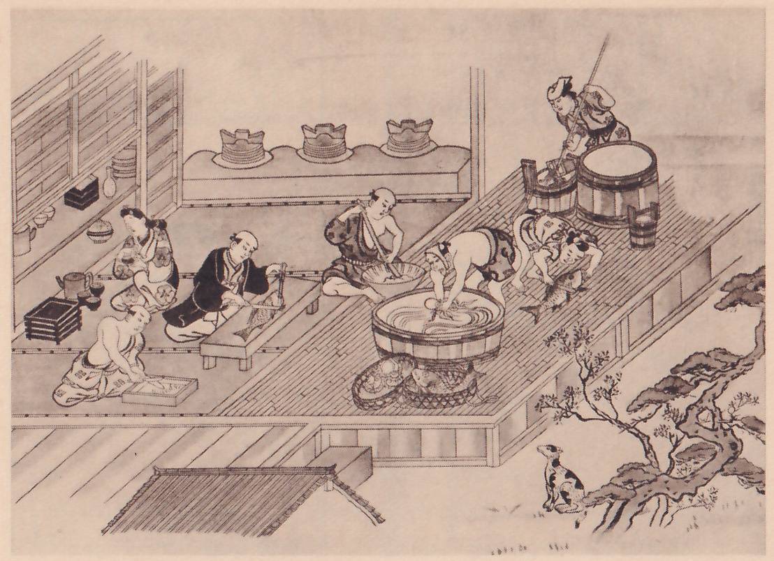 Black-and-white print of a room with a slatted floor, seen from above at an angle, open to a garden on the right. Figures work around a large round tub at the center, one bending over it, one kneeling at the right with a fish; others sit along the left at low boards and boxes, one cutting a fish on a board, and one stands at the upper right behind large barrels, holding a long pole. Three stacked vessels stand on a raised shelf along the back. A small spotted animal sits at the lower right beside a twisted pine, and a small matted roof shows at the lower left.