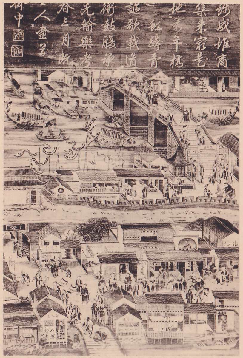 Black-and-white picture of a town beside a canal, with a dark band across the top filled with columns of Chinese characters and square seals at the left. Below it a bridge with stairs crosses the water, with small figures on it, and boats lie along the left bank. In the lower half rows of tiled-roof buildings line lanes full of tiny figures, with a clump of trees at the center left.
