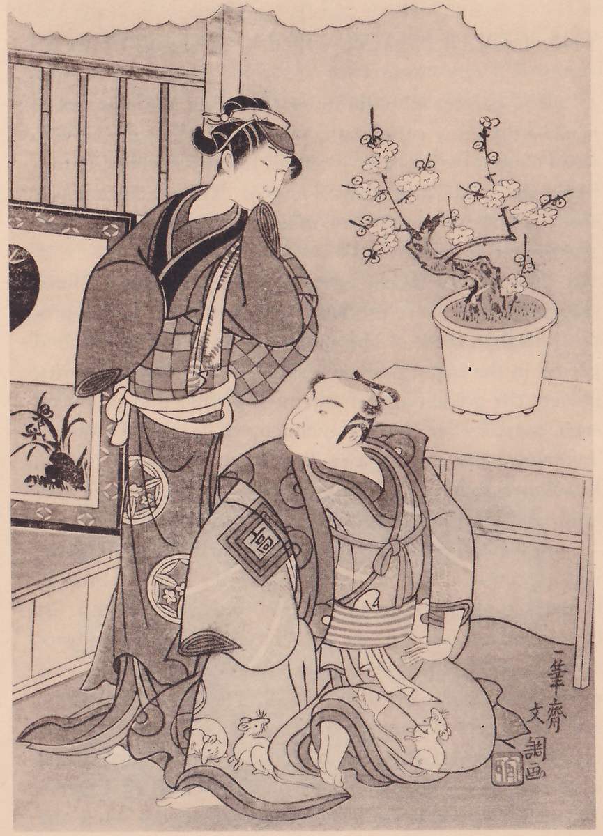 Black-and-white print of two figures in a room. One stands at the left in a checked robe, the head tilted and one hand raised to the chin. The other kneels at the lower center in a robe with a square crest on the sleeve and round crests, looking up and to the left, with small animals drawn along the hem. Behind them a low table at the right holds a pot with a flowering branch, a framed picture stands at the left behind a railing, and a scalloped edge runs along the top. A signature column and a seal stand at the lower right.
