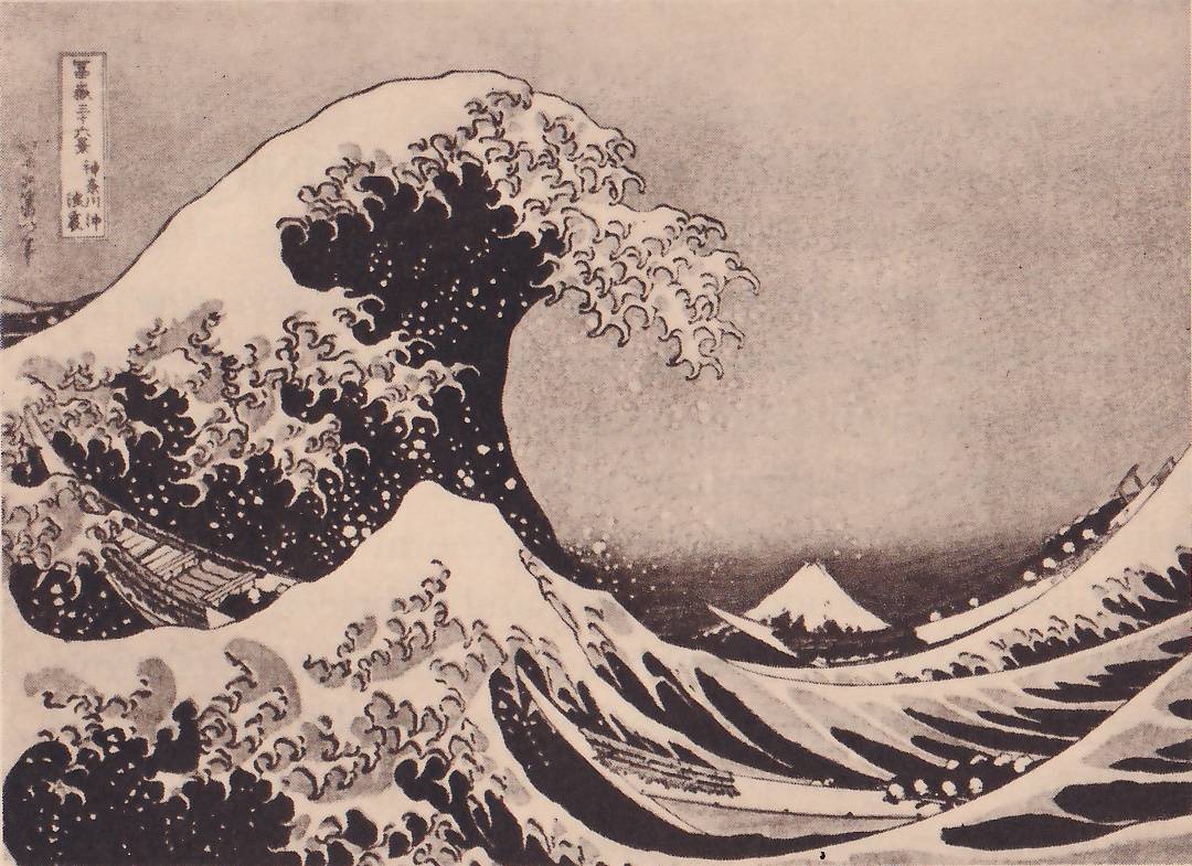 Black-and-white print of a huge wave curling over from the upper left, its crest breaking into claw-like fingers of foam, with spray dotted across it, above a trough of dark water streaked with pale lines. A long narrow boat lies in the water at the left and another at the lower right. A small mountain with a pale peak stands low on the horizon at the center right between the waves. A framed label of Japanese characters stands at the upper left.