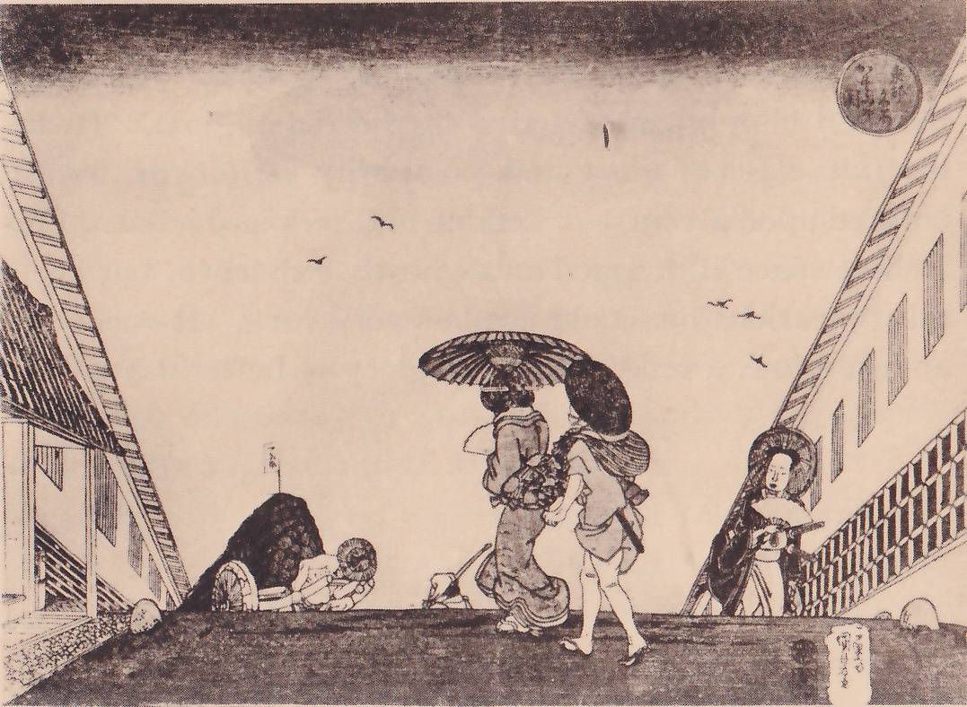 Black-and-white print of a street seen from a low viewpoint, with long buildings sloping in toward the center on both sides and a flat dark ground across the bottom. Small birds fly in the open sky, under a dark band along the top. Two figures walk together at the center under large umbrellas. At the right a figure in a dark robe, with a large round shape behind the head, holds a fan. At the left a dark rounded mound with a wheel at its foot stands beside a figure bending over, and a small animal stands near the center. A round seal with Japanese characters stands at the upper right and a label at the lower right.