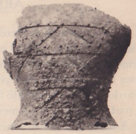 Black-and-white photograph of a similar waisted object with a roughened surface, set beside the other. Straight horizontal lines run across it, with a row of small dots along the top one, and slanting lines form a triangle pattern between them.