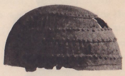 Black-and-white photograph of a half-dome seen from the side, with several horizontal rows of small dots across it, a small break near the top right edge, and a ragged lower edge.