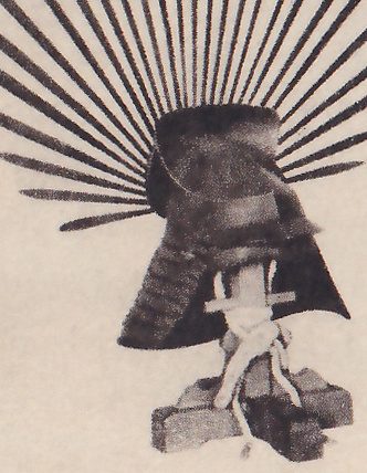 The lower left of four black-and-white photographs on the page: a dark bowl-shaped piece on a small stand of rough blocks tied with pale cord, with a wide fan of thin straight spikes spreading out behind its top.