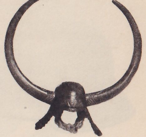 The upper right of four black-and-white photographs on the page: a small dark rounded cap with two long thick curved horns sweeping up from its sides in an almost closed circle, and two short strips hanging below it.