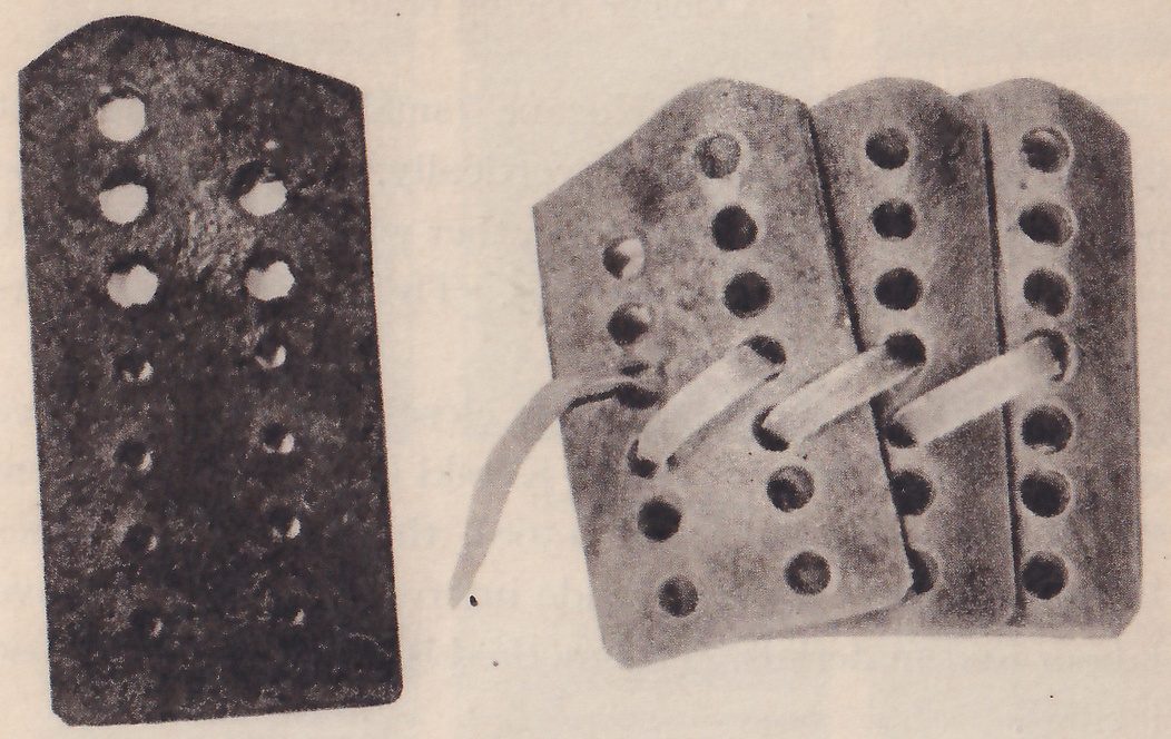 Black-and-white photograph of flat plates with holes in them. At the left, one dark narrow plate with a clipped upper right corner has two columns of holes, the upper ones larger. At the right, three pale narrow plates overlap side by side, with round holes in columns, and one pale flat strip is threaded through holes across all three.