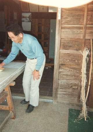 Mr. Fukunishi brushes paper onto the drying board