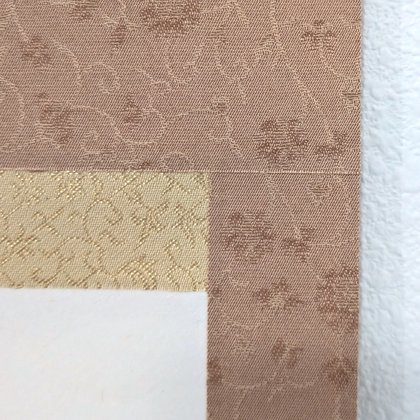 The corner where the paper, the gold band and the brocade border meet